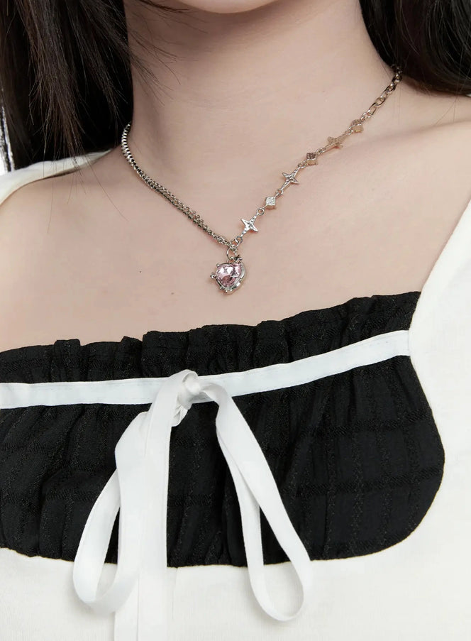 LEWKIN Double Chain Heart Pendant Necklace IO527 in Silver, close-up on model's neckline, pink heart crystal pendant with star-charm chain, layered over black ribbon-tie top.