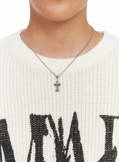 LEWKIN Men's Cross Chain Pendant Necklace IS509 in silver, close-up on model's chest, ornate cross pendant on curb chain, layered over cream chunky-knit sweater.