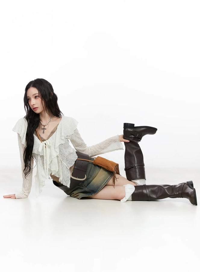LEWKIN Vintage Wash Denim Mini Skirt CM518 in vintage blue, full editorial shot on seated model, washed cotton denim with amber fade, styled with white lace top and dark brown knee-high boots.