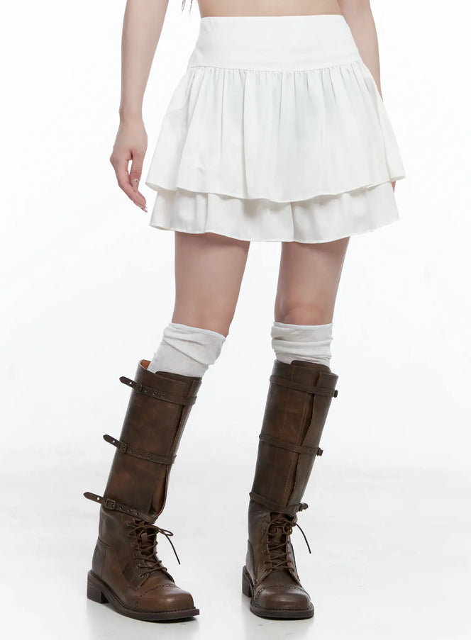 LEWKIN Double Layered Ruffle Mini Skirt CS501 in white, side-angle close-up on model, double-tiered flare ruffle hem, paired with white leg warmers and brown combat boots.