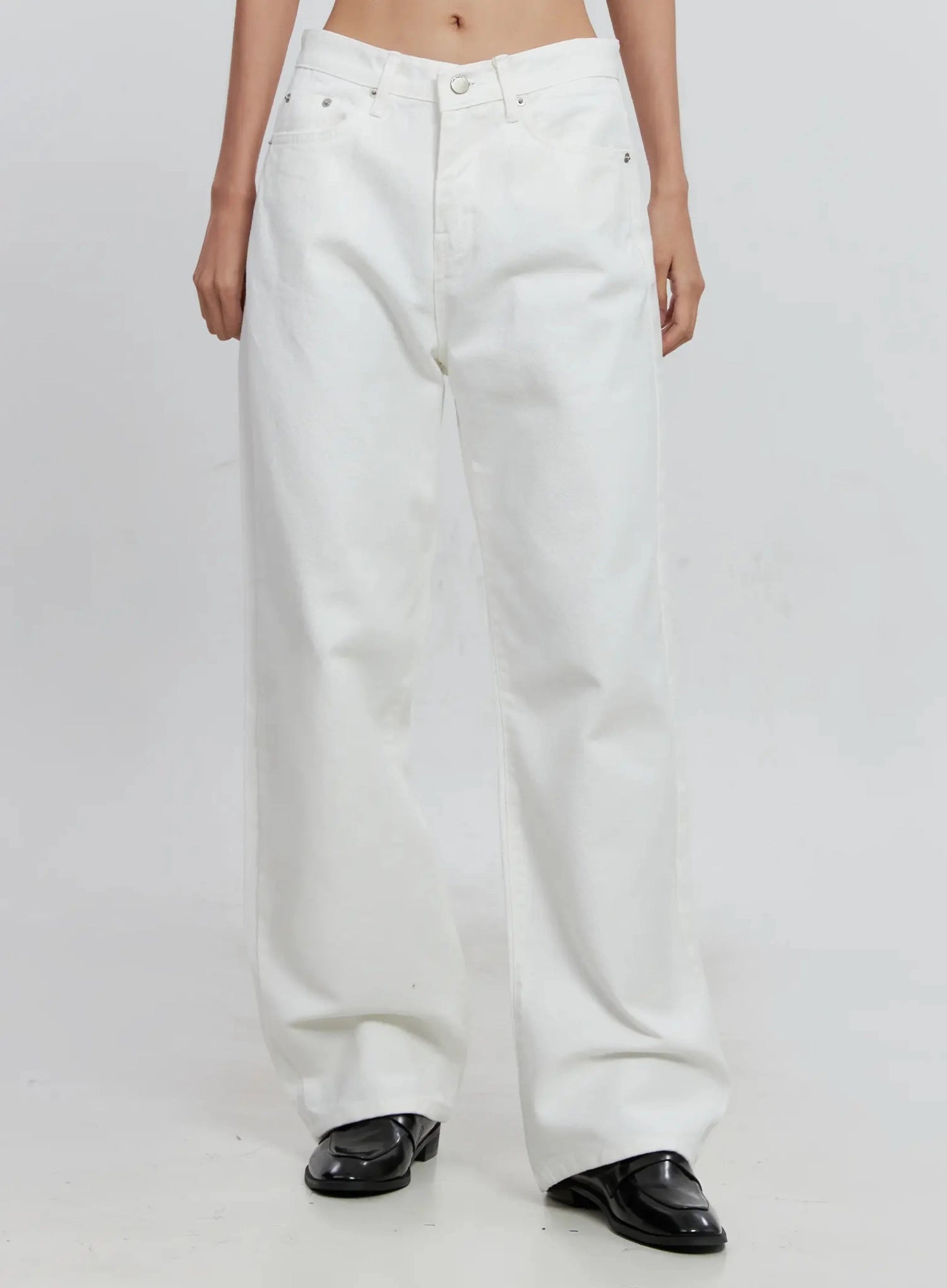 LEWKIN Taytum Straight-Leg Jeans IS515 in white, front crop view on model, low-rise straight-leg cotton denim, silver rivets, paired with black loafers.