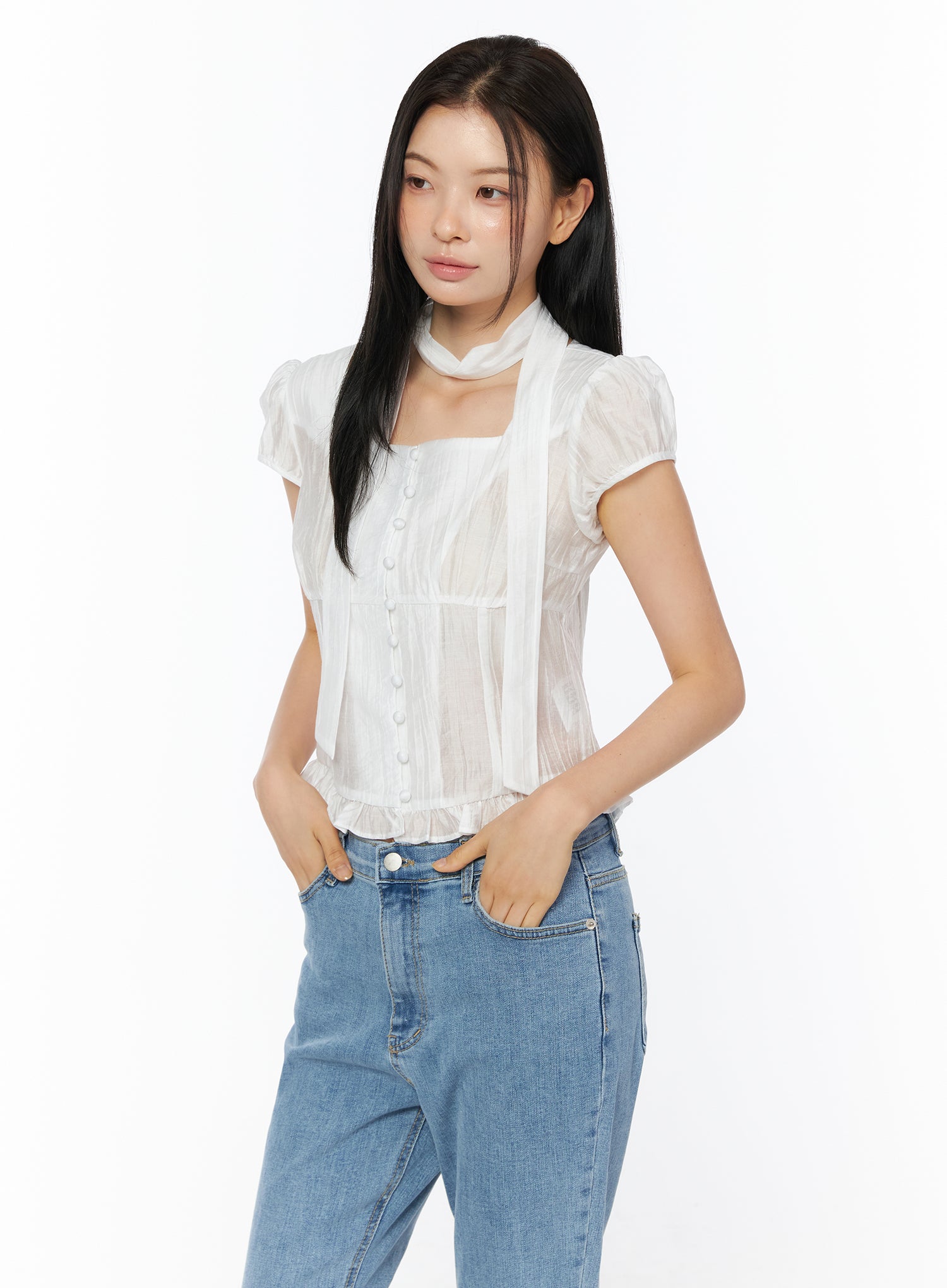 LEWKIN Puff Sleeve Shirred Blouse with Scarf IU519 in white, 3/4 front view on model, sheer nylon-tencel square neck with center button placket, ruffled hem and scarf, styled with blue jeans.