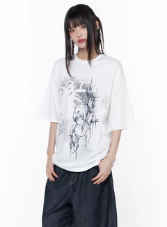 LEWKIN Casual Graphic Short Sleeve Top CU519 in White, front half-body shot on model, oversized cotton tee with dark anime girl and thorn illustration, paired with wide-leg dark denim.