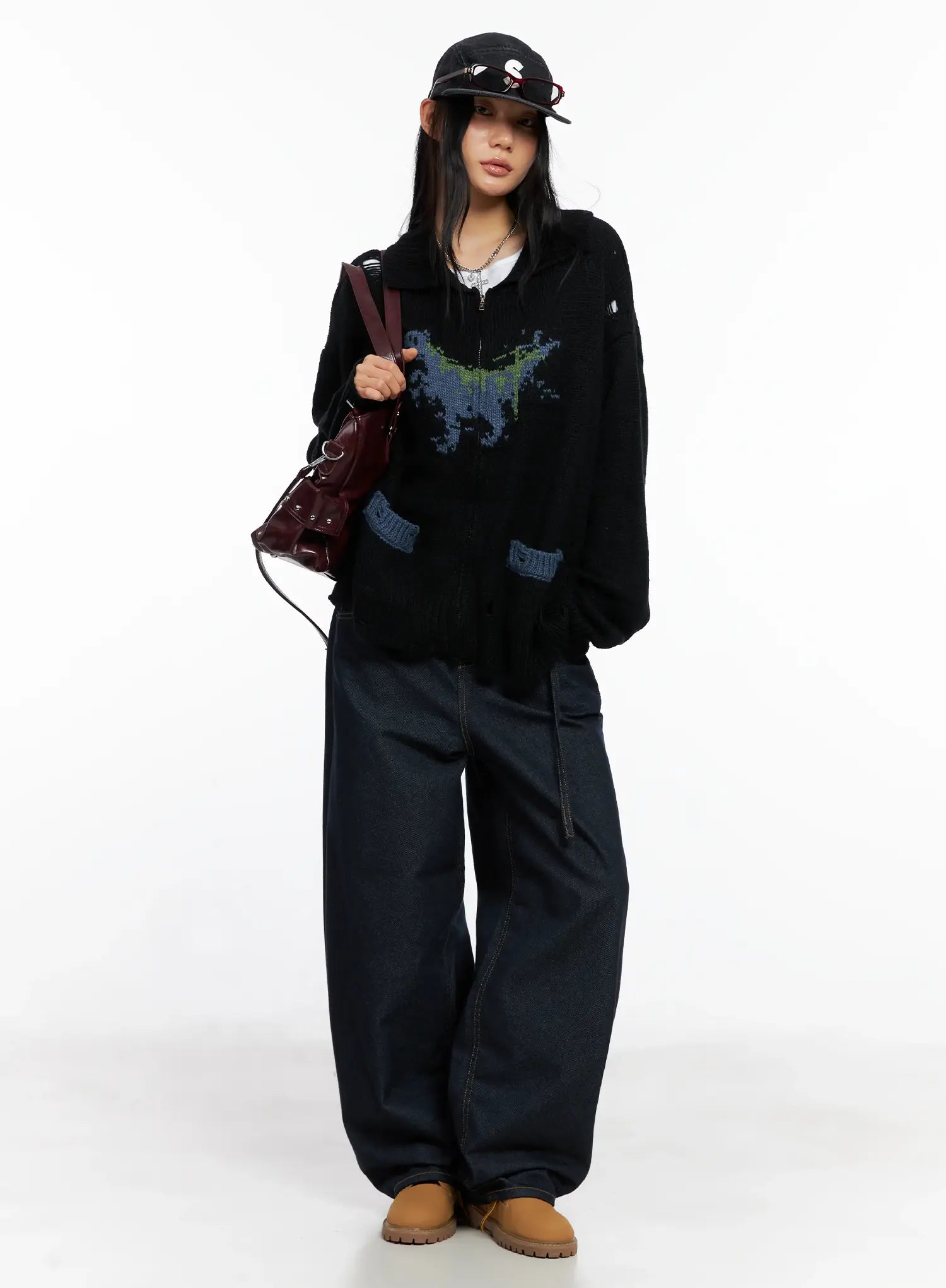 LEWKIN Alanna Sun Belt Baggy Jeans CO528 in dark indigo, full-body front view on model, loose cotton denim with wide leg, styled with black graphic knit zip-up, cap, and burgundy bag.