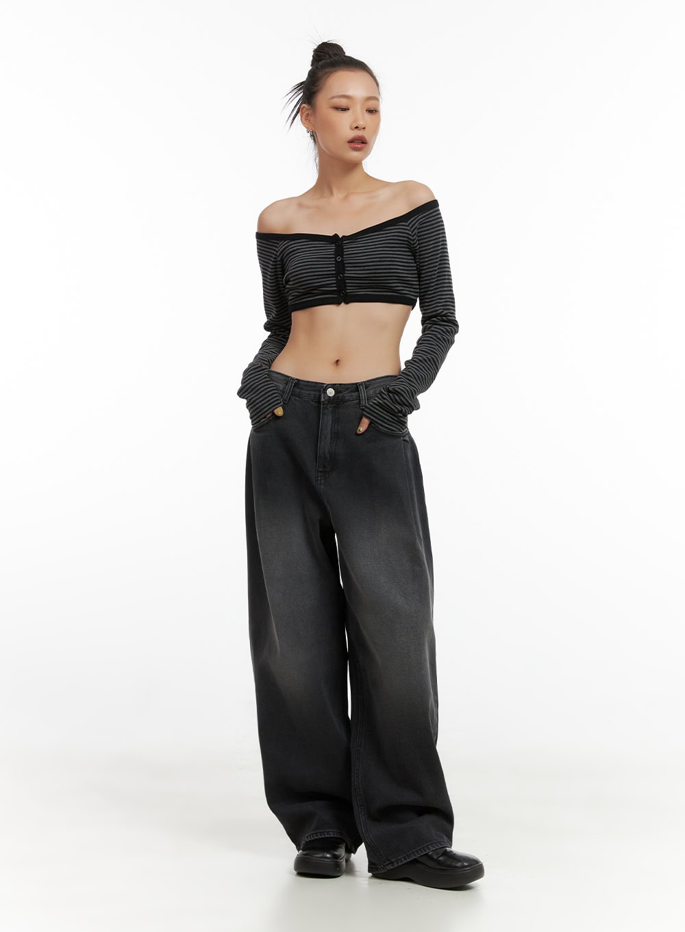 LEWKIN Delilah Pin-Tuck Washed Denim Baggy Jeans CO424 in black, full-length front view on model, wide-fit washed cotton denim with pintuck detail, paired with striped crop top and chunky black shoes.