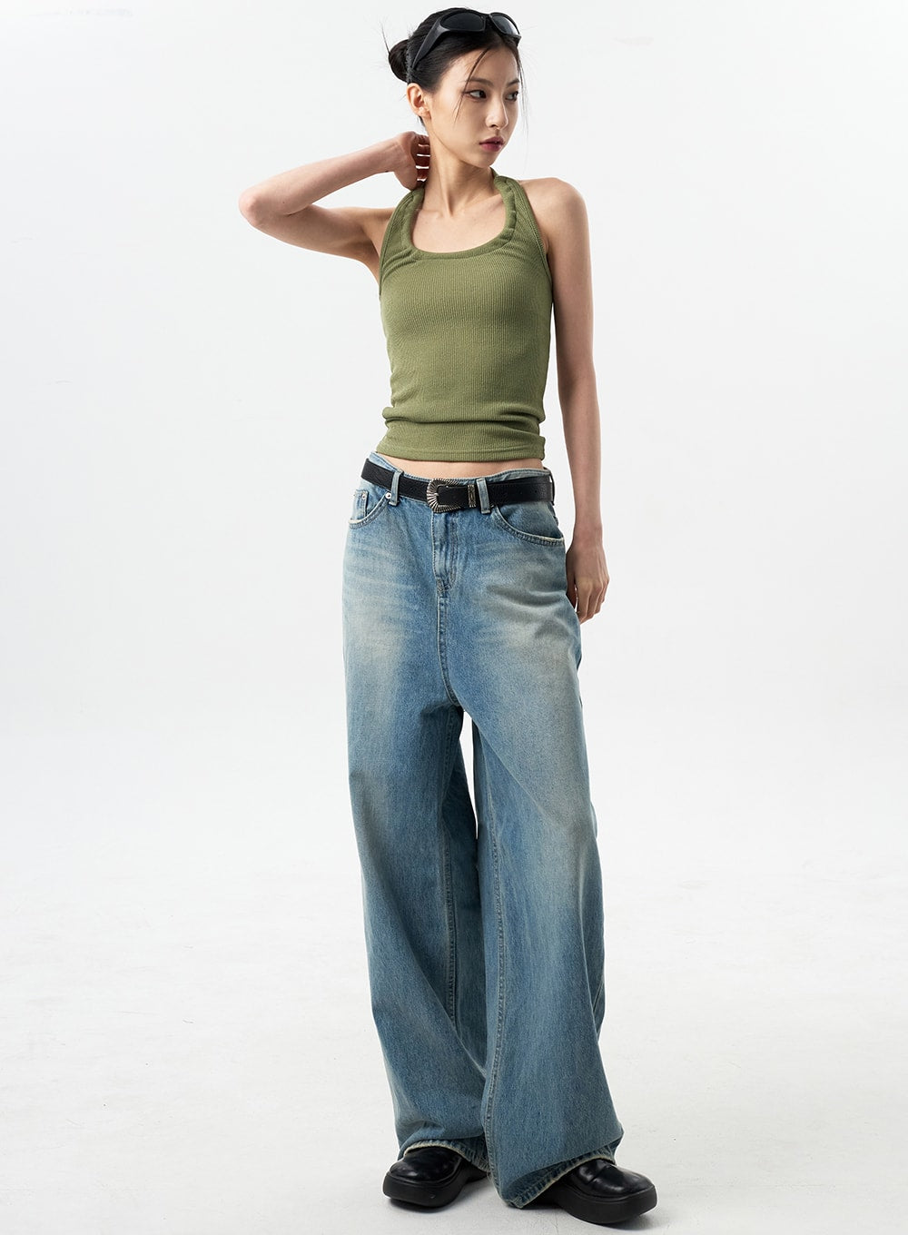 LEWKIN Oversized Jeans Unisex CY312 in washed blue, full-length front view on model, wide-leg denim with faded wash, paired with green halter top and black belt.