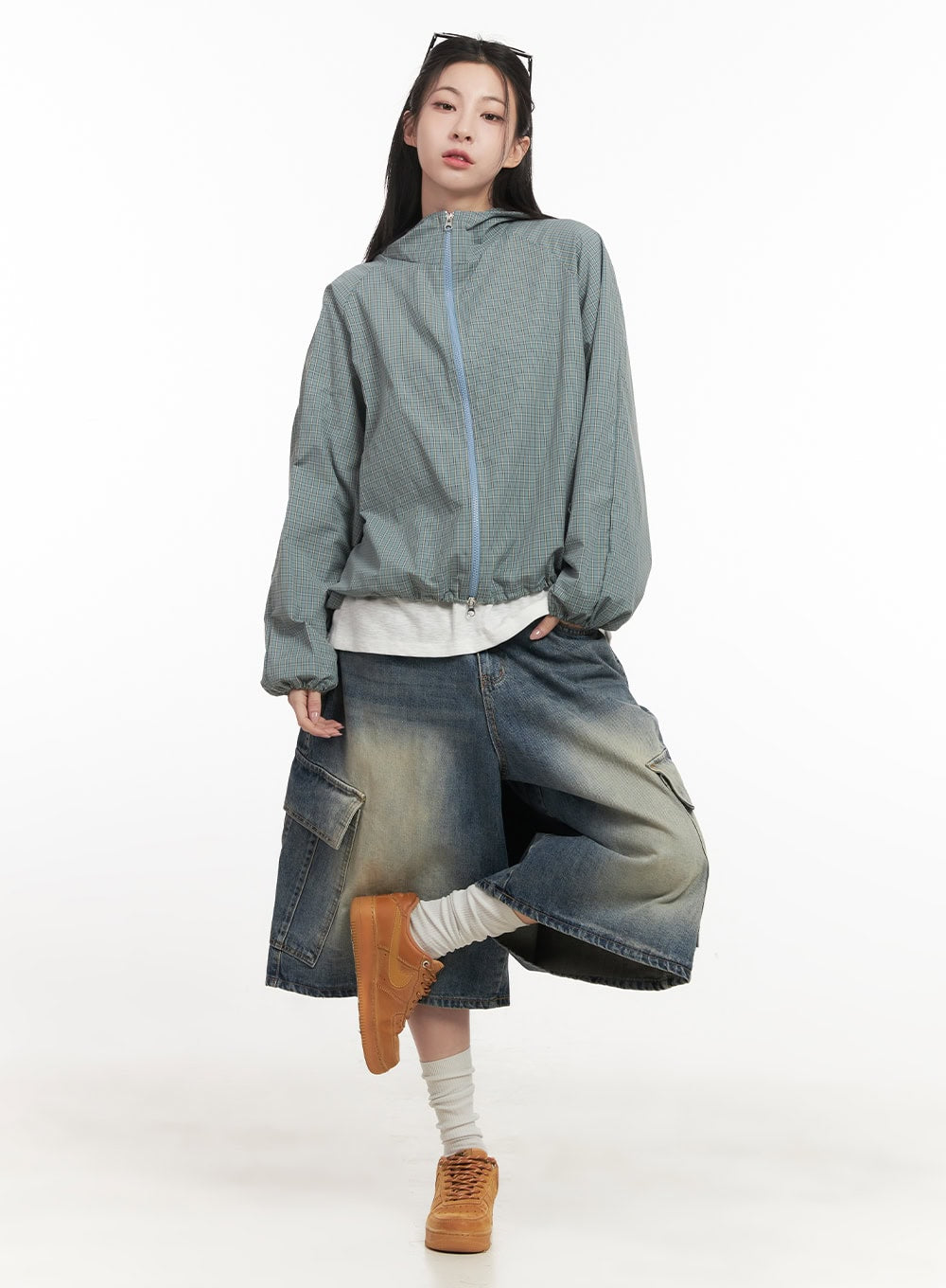 Cargo Bermuda Denim Shorts CF514 in dark blue, full-body editorial shot on model, wide-fit washed denim, styled with a sage green hooded zip jacket and tan sneakers.