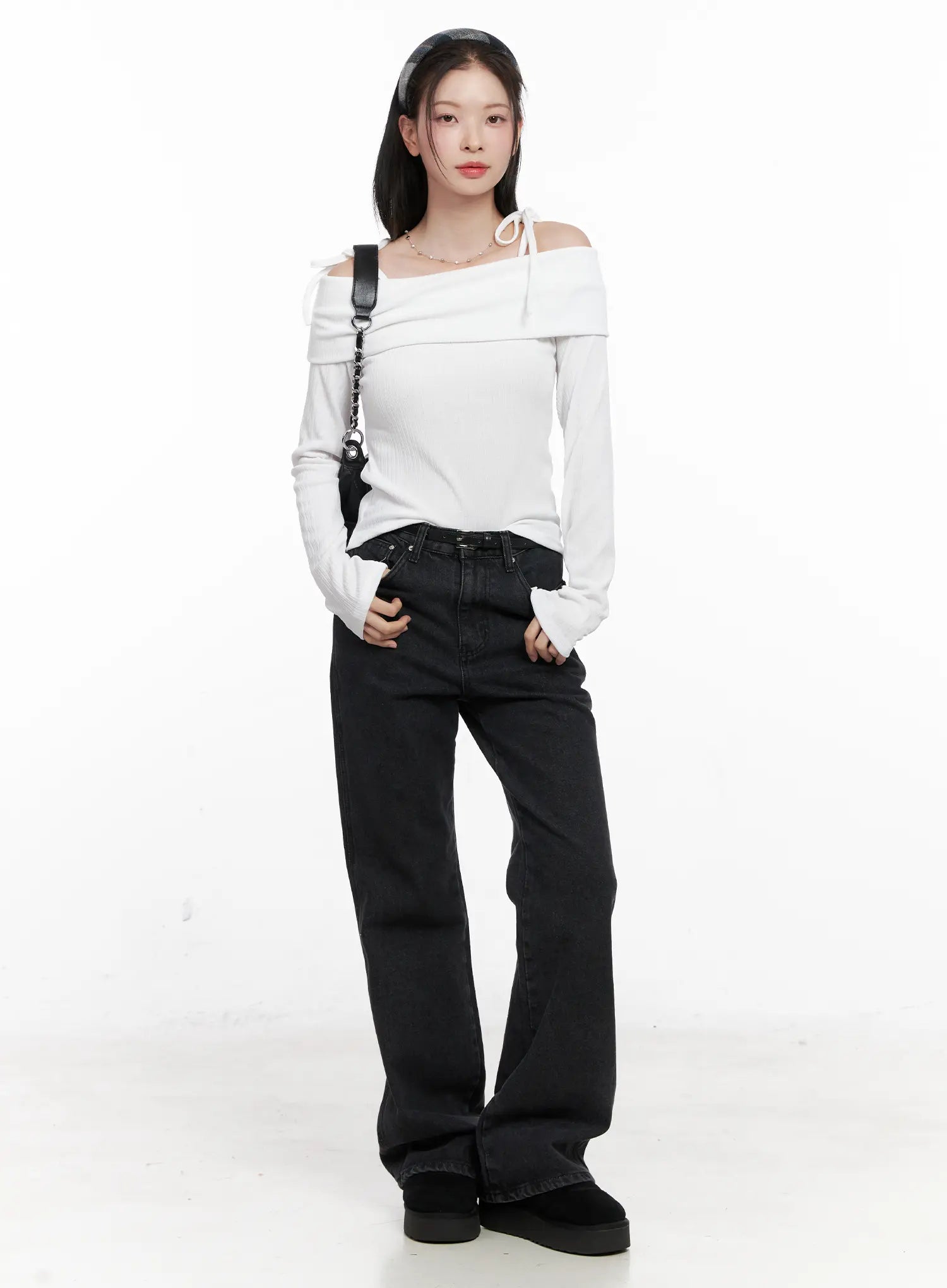 LEWKIN Eileen Belted Flare Jeans CN504 in washed black, full-length front view on model, loose flare cotton denim with leather belt, styled with white off-shoulder top and black platform shoes.