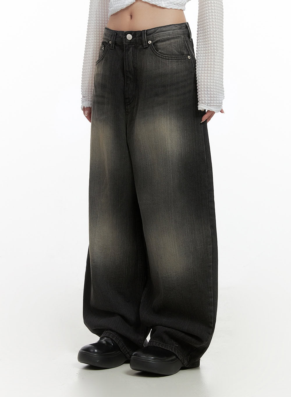 LEWKIN Sage Back-Buttoned Wide Pants CS430 in black, front three-quarter crop on model, washed denim with faded golden-brown whisker detail, ultra-wide leg, paired with white waffle crop top and black platform loafers.