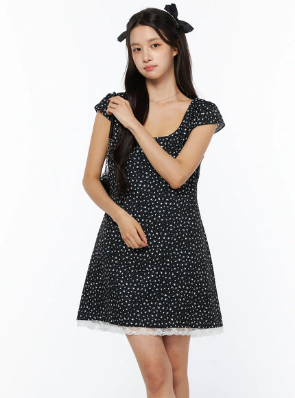 LEWKIN Floral Lace Trim Mini Dress CU522 in black, three-quarter front view on model, ditsy floral print with white lace hem trim, cap sleeves, square neckline, A-line silhouette.