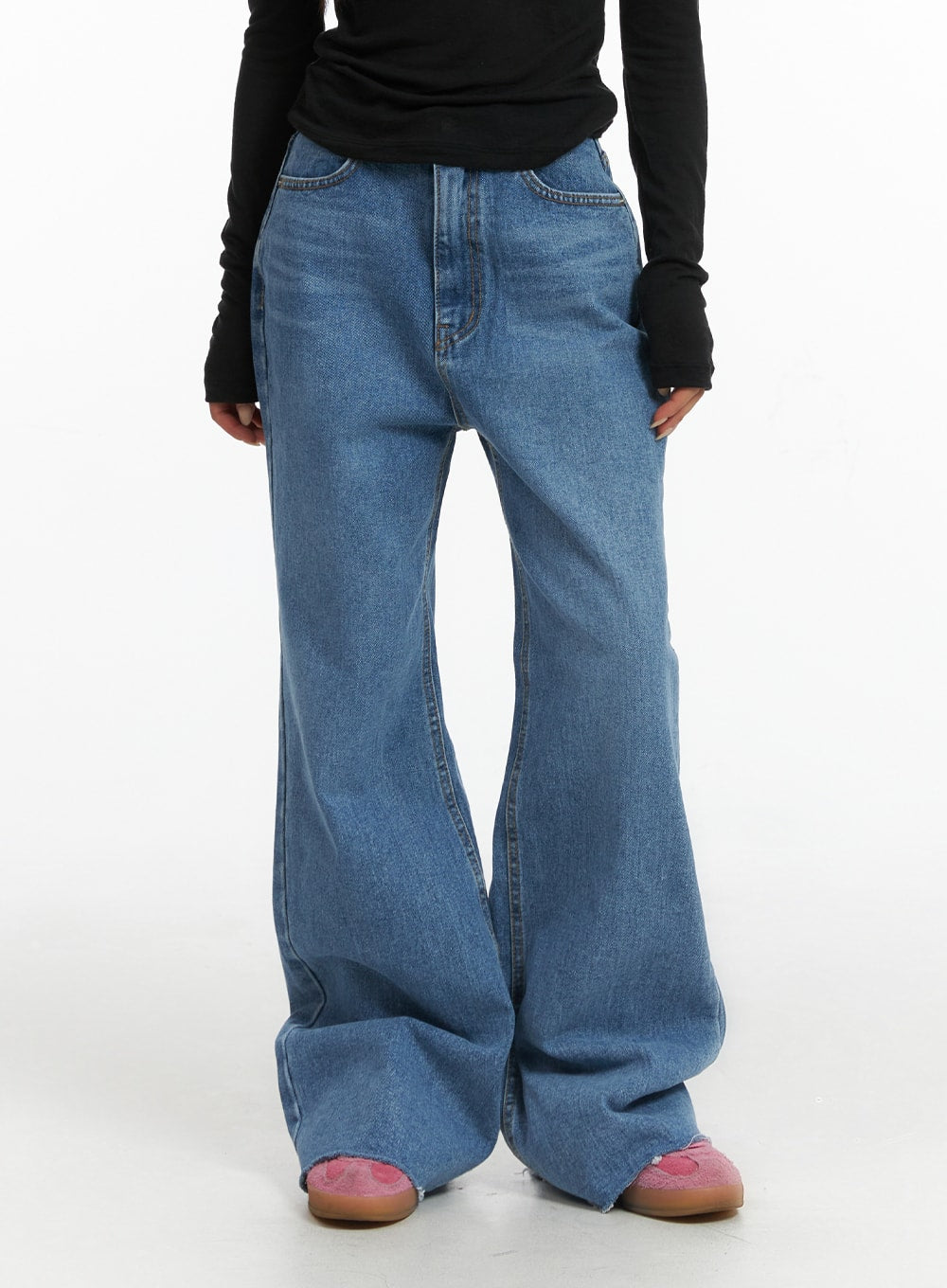 LEWKIN Blue Denim Bootcut Jeans CJ431 in blue, front close-up on model, washed cotton denim with wide bootcut flare, raw hem pooling at ankles, paired with black long sleeve top and pink mules.