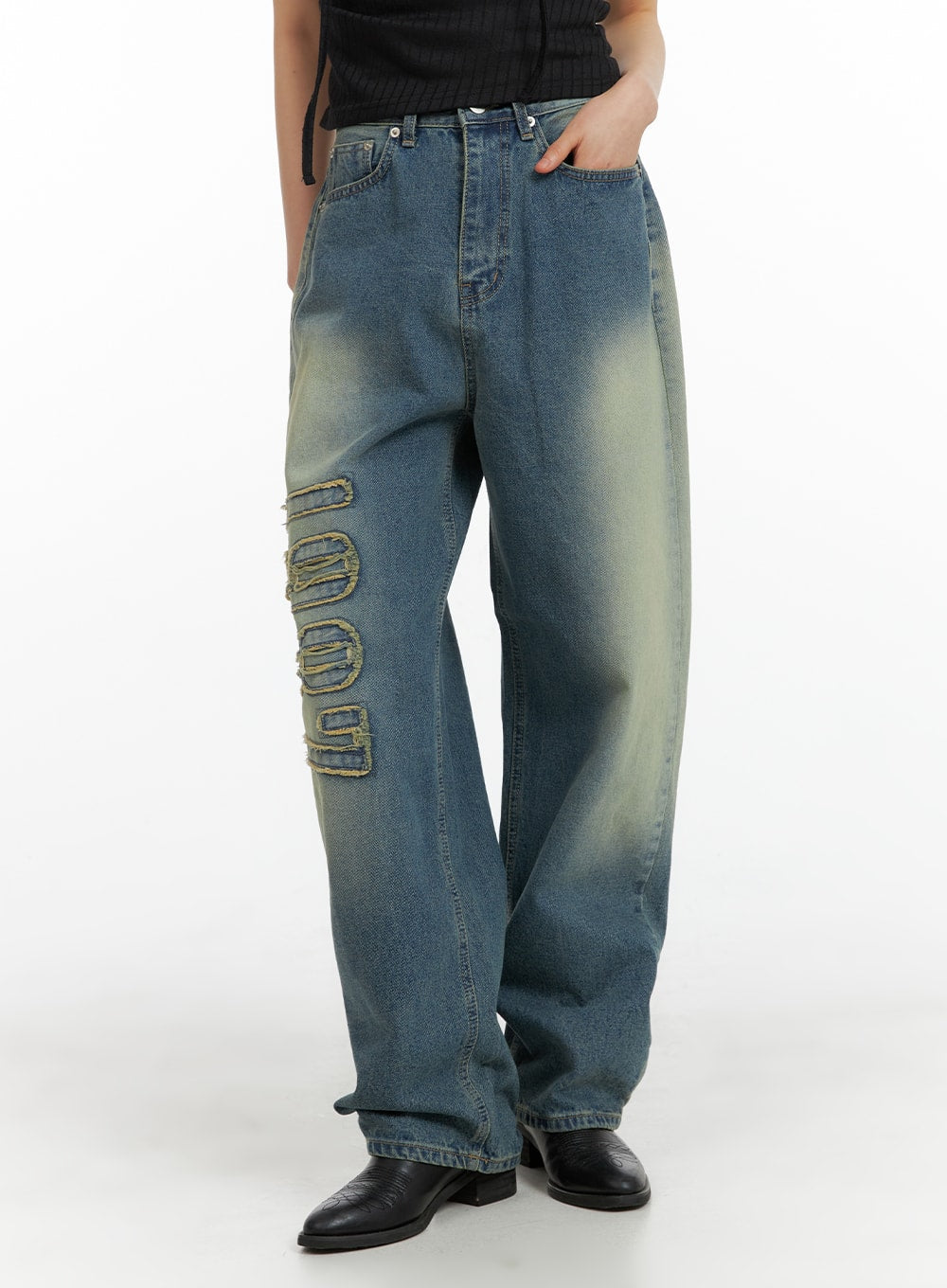 LEWKIN Distressed Baggy Straight Jeans CM413 in blue, front three-quarter crop on model, wide-fit washed denim with raised frayed '1987' graphic appliqué on left leg, paired with black boots.