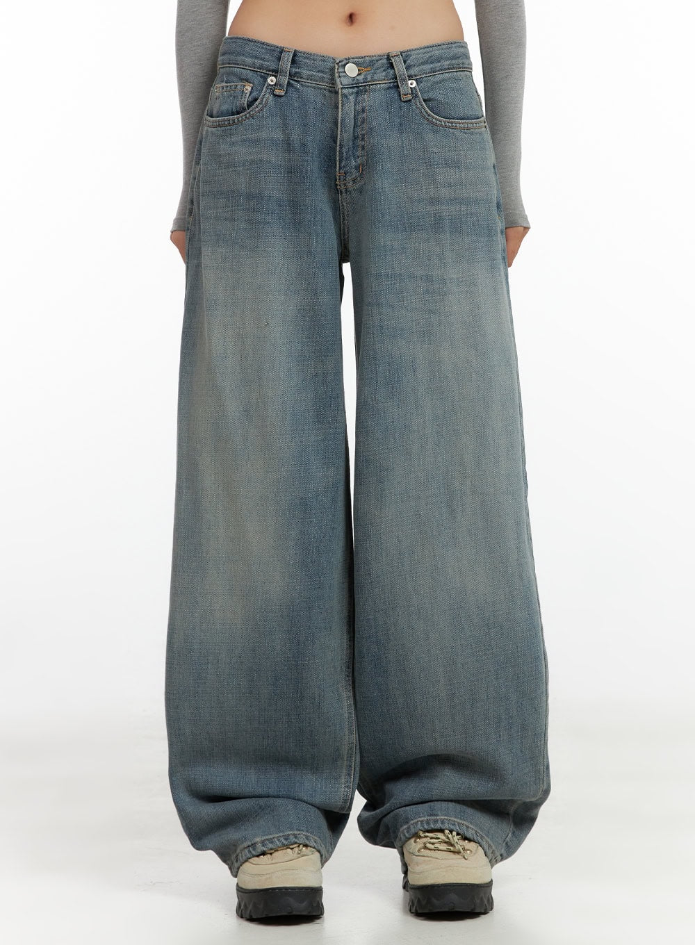 LEWKIN Nadia Washed Low-Waist Baggy Jeans CO424 in blue, front close-up on model, washed wide-leg denim with low waist, V-shaped waistband, paired with grey crop top and chunky sneakers.