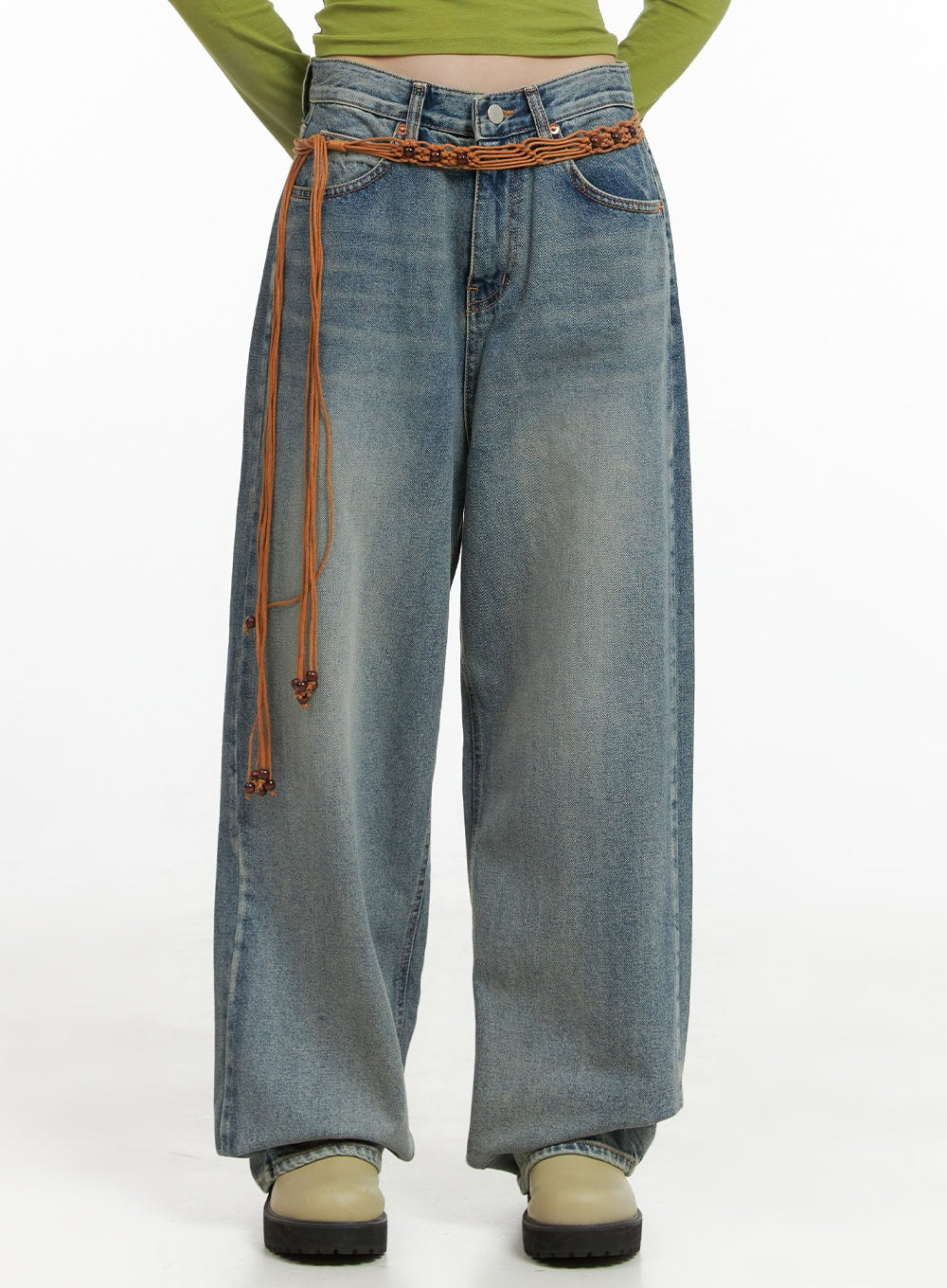 LEWKIN Millie Washed Baggy Jeans CG421 in Blue, front waist-down shot on model, wide-fit washed cotton denim with braided brown belt, paired with green crop top and chunky boots.