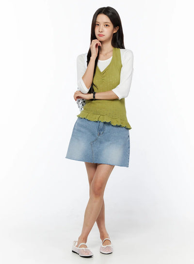 LEWKIN Casual Denim Mini Skirt CU522 in light blue, full-length front on model, A-line silhouette with raw hem, styled with green knit vest over white tee and floral flats.