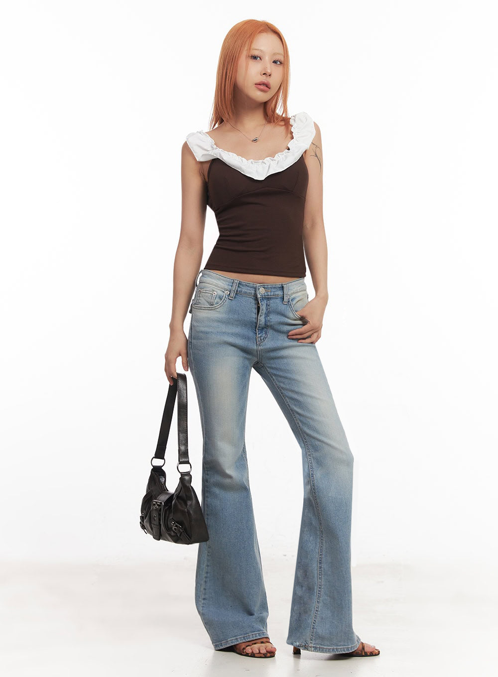 LEWKIN May Washed Flared Jeans IA515 in light blue, full-body front on model holding black bag, slim-fit flared denim with washed finish, paired with brown ruffle crop top and strappy heels.