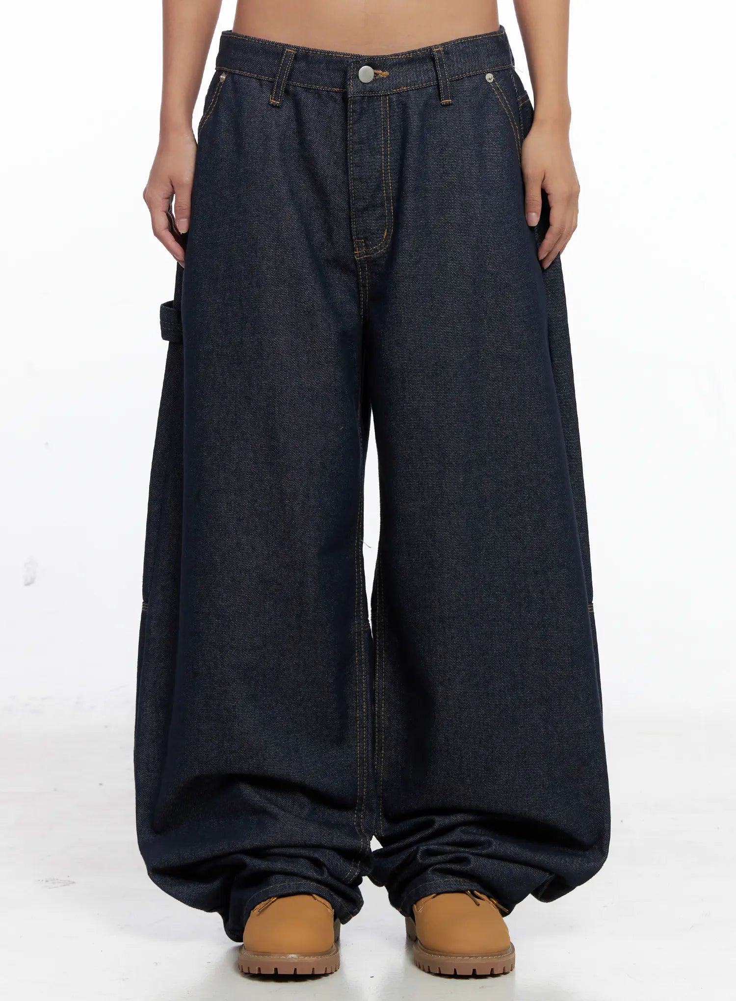 LEWKIN Relaxed Fit Dark Denim Jeans CS522 in dark blue, front product shot on model, ultra-wide baggy leg with contrast topstitching, low rise, carpenter pocket detail, paired with tan boots.