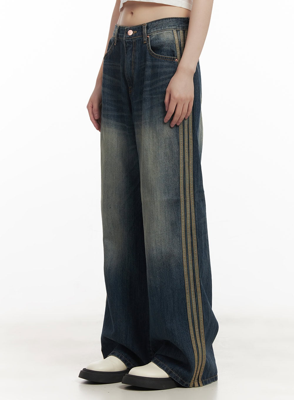 LEWKIN Daisee Striped Wide-Leg Jeans CF518 in dark blue, side close-up on model, washed cotton denim with triple gold stripe detail, wide-leg silhouette, paired with white shoes.