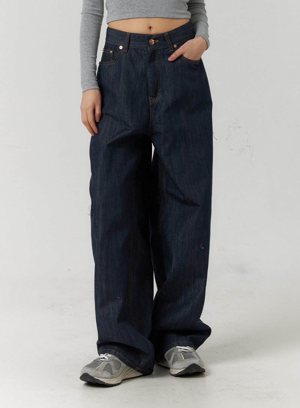 LEWKIN Back Button Wide Leg Jeans CF407 in blue, front cropped view on model, dark indigo denim wide-fit silhouette with copper rivets, paired with grey crop top and sneakers.