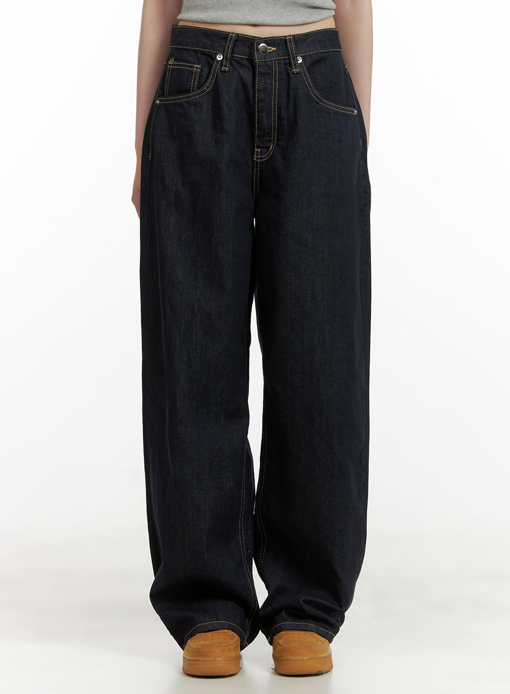 LEWKIN Stitch Detail Baggy Jeans CU410 in dark blue, front crop view on model, wide-fit cotton denim with contrast topstitching, five-pocket styling, paired with grey crop top and tan sneakers.