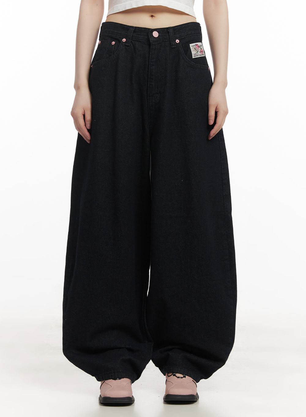 LEWKIN Dory Embroidered Baggy Jeans CF518 in dark blue, front view on model, oversized wide-leg cotton denim with pintuck, patch label, pink rivets, paired with white crop top.