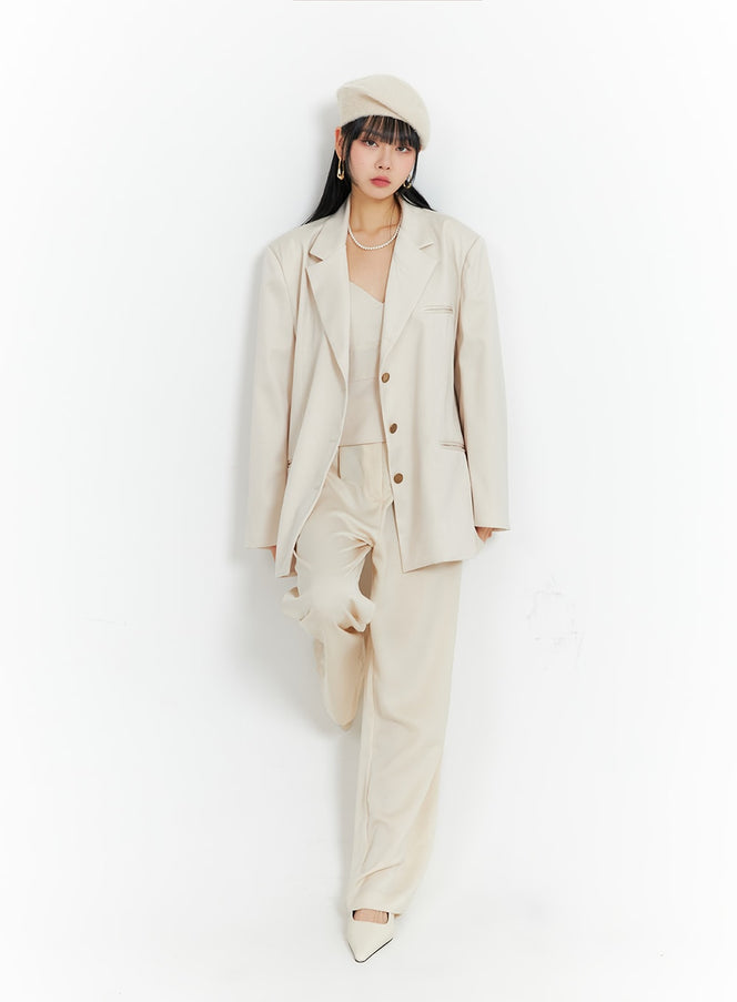 LEWKIN Solid Wide Leg Trousers IF402 in light beige, full-length front view on model, wide-fit tailored trousers with front pleats, styled with matching blazer and cami top, white heels and beret.