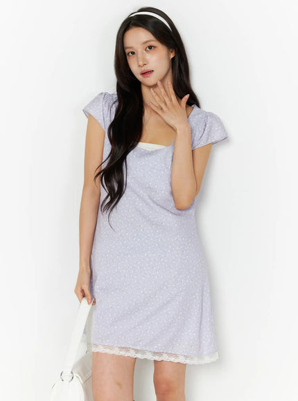 LEWKIN Romantic Floral Lace Trim Mini Dress CU522 in light purple, front three-quarter view on model, floral print cap sleeves, square neckline, cream lace hem, styled with white headband and bag.
