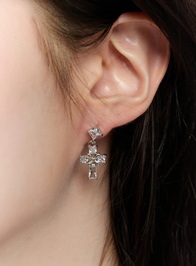 LEWKIN Elegant Cross Drop Earrings CM505 in silver, extreme close-up worn on model's ear, crystal bead cross pendant with square stud top and baguette drop detail.