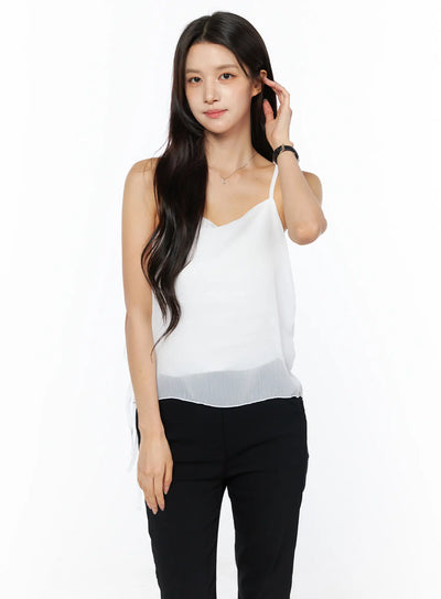 LEWKIN Sheer Ribbon Cami Top CU522 in white, front view on model, sheer crinkle fabric, V-neck with thin straps, semi-transparent hem, paired with black trousers.