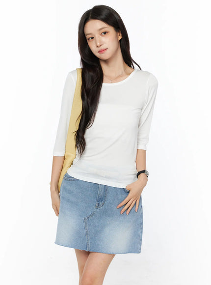 LEWKIN Sheer Three-Quarter Sleeve Top CU522 in white, front three-quarter shot on model, slim fit sheer knit with round neck, styled with blue denim mini skirt and yellow shoulder bag.
