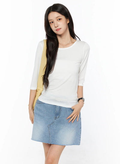 LEWKIN Sheer Three-Quarter Sleeve Top CU522 in white, front three-quarter shot on model, slim fit sheer knit with round neck, styled with blue denim mini skirt and yellow shoulder bag.