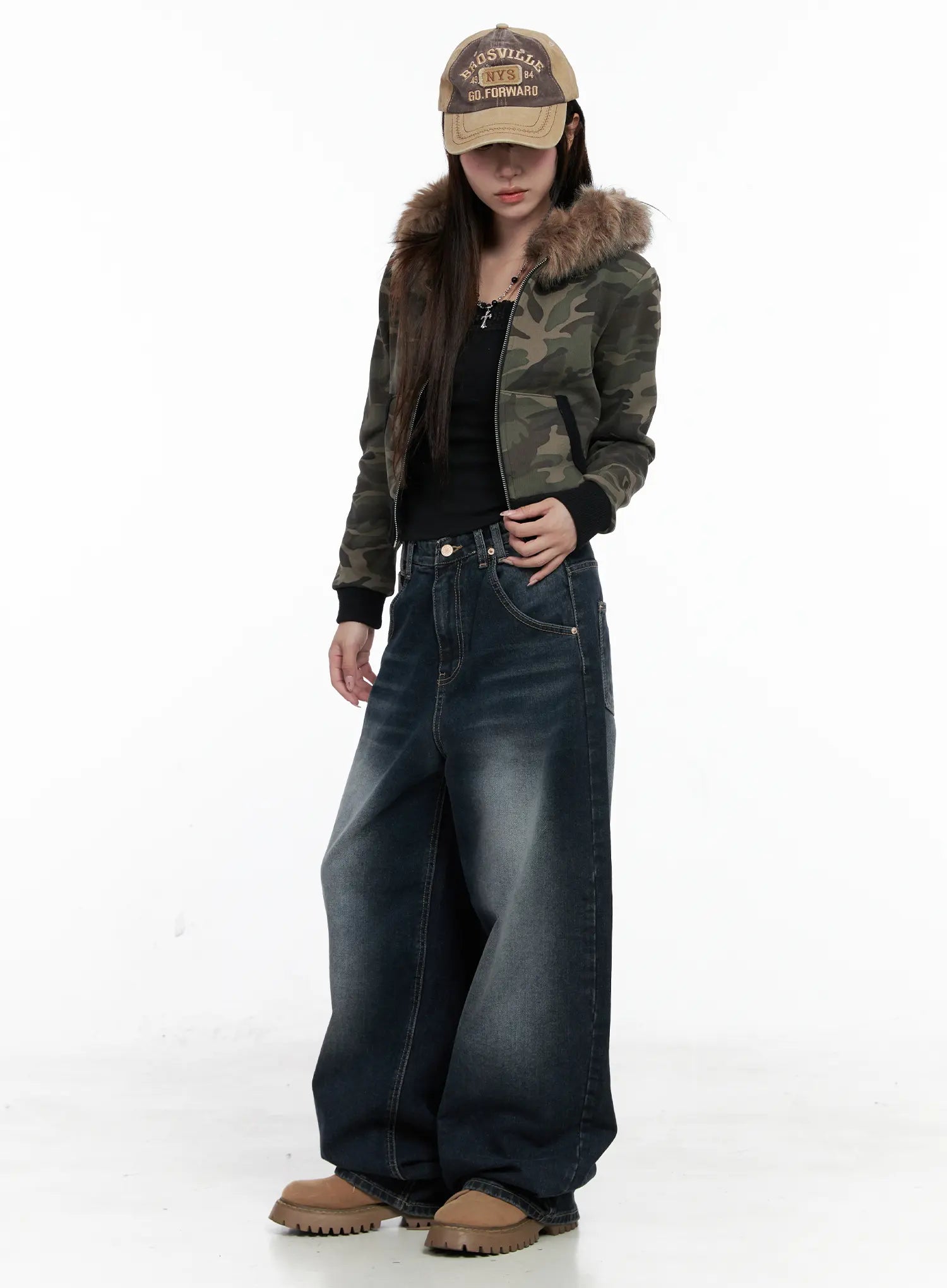 Isla Washed Baggy Jeans CO521 in dark blue, full-body front shot on model styled with camo fur-hood jacket and baseball cap, ultra-wide leg pooling at chunky boots.
