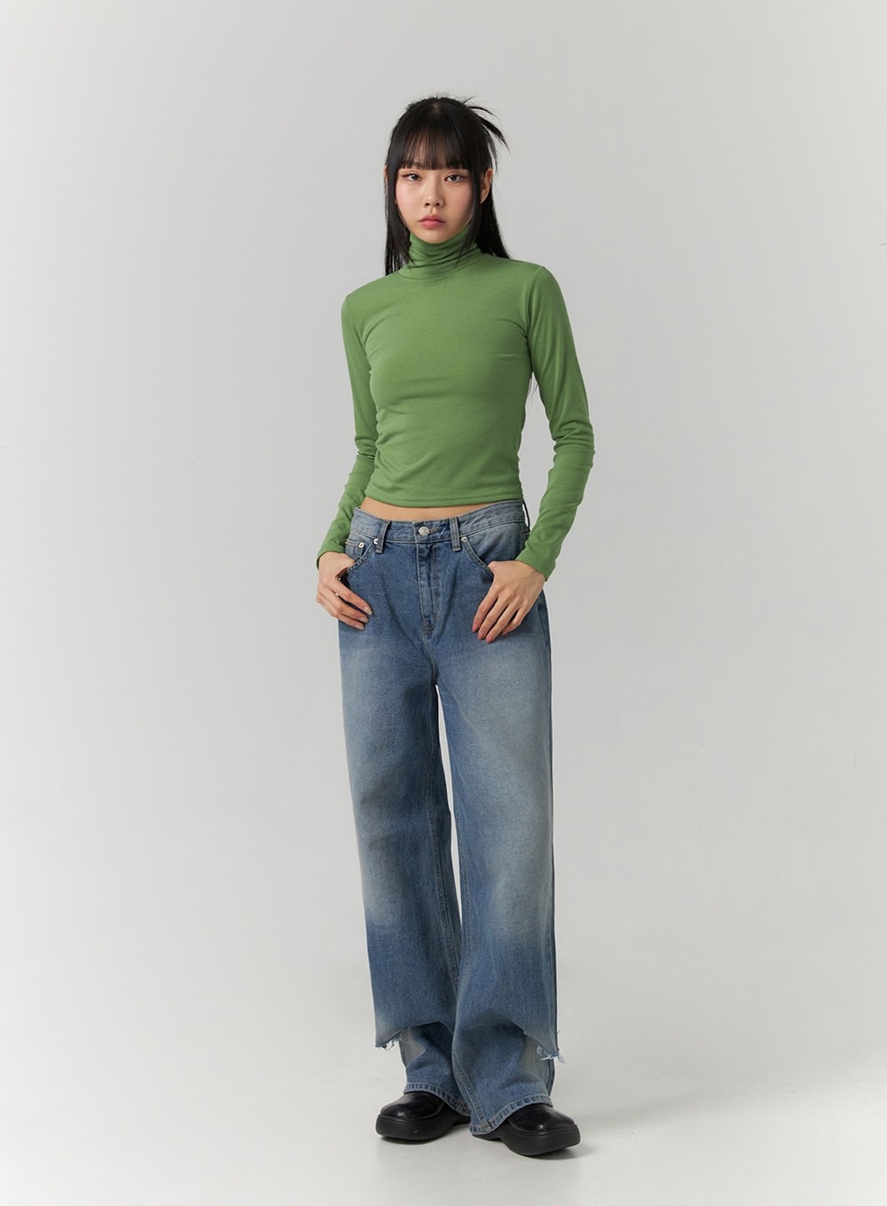Ripped Straight Leg Jeans CD308 in blue, front full-body shot on model, relaxed wide-leg washed denim with frayed lower hem, paired with green cropped turtleneck top.