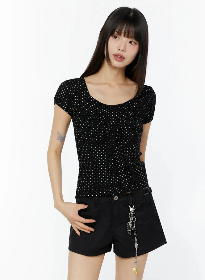 Polka Dot Puff Sleeve Top IU518 in black, front view on model, slim fit with white dot pattern, U neckline, puff short sleeves, styled with black shorts and charm belt.
