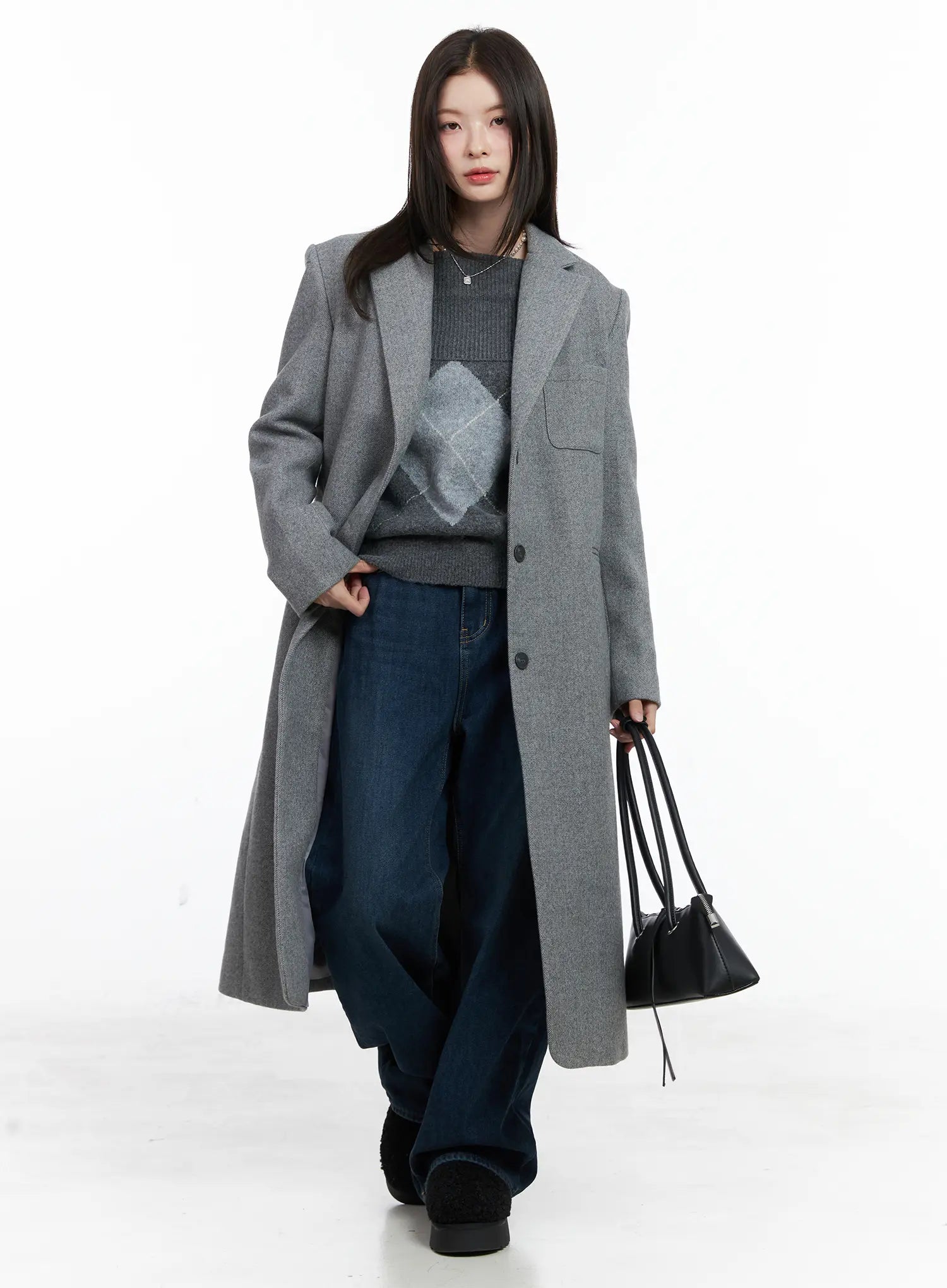 Jordan Velvet Fleece Wide Jeans CN518 in blue, full-body styling shot, model walking in long grey wool coat layered over argyle knit, carrying black bag.