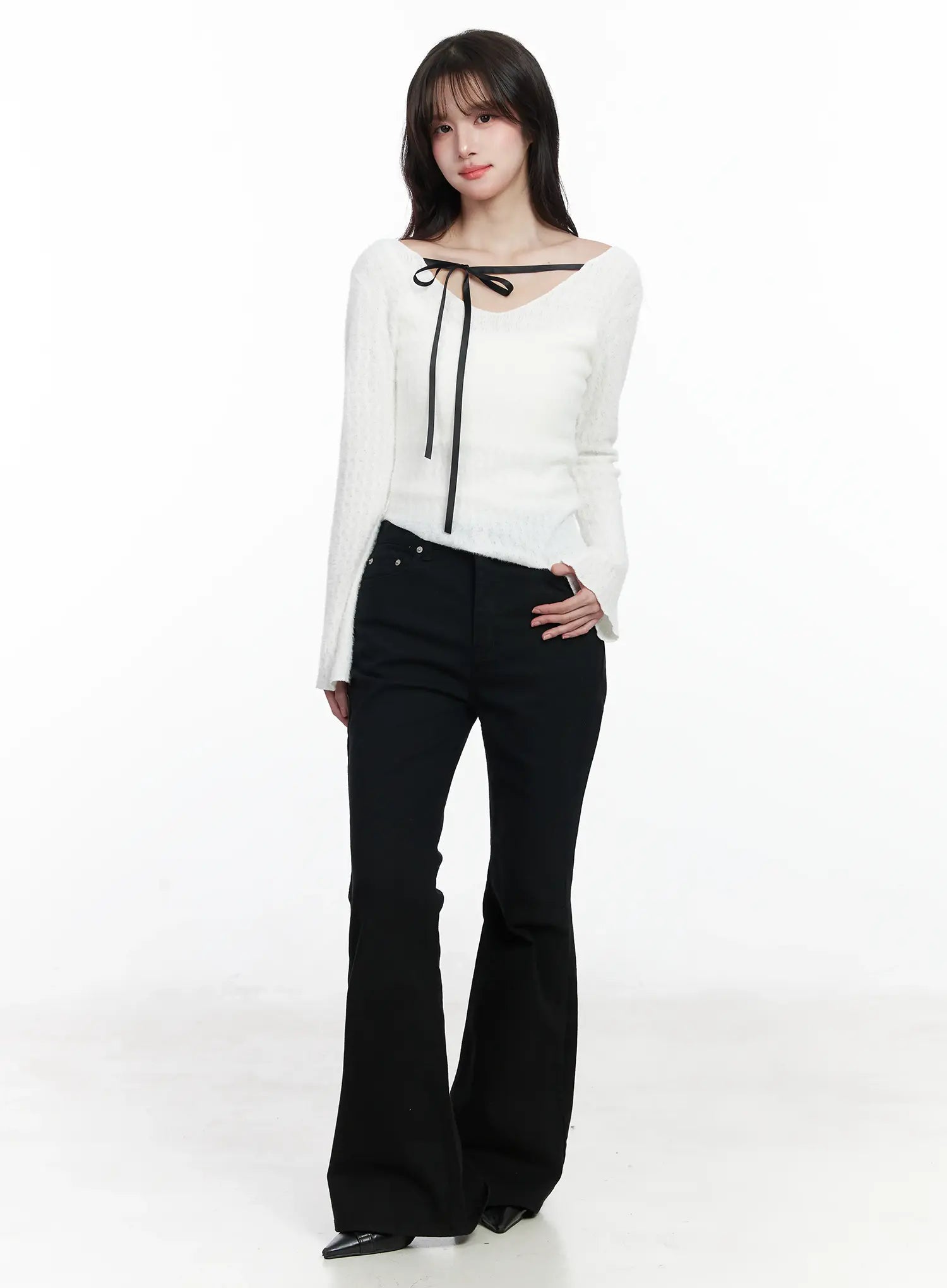 Ellis High-Waist Bootcut Jeans IJ529 in black, full-body front worn shot on model, long bootcut silhouette styled with white ribbon-tie fuzzy knit top and black heels.
