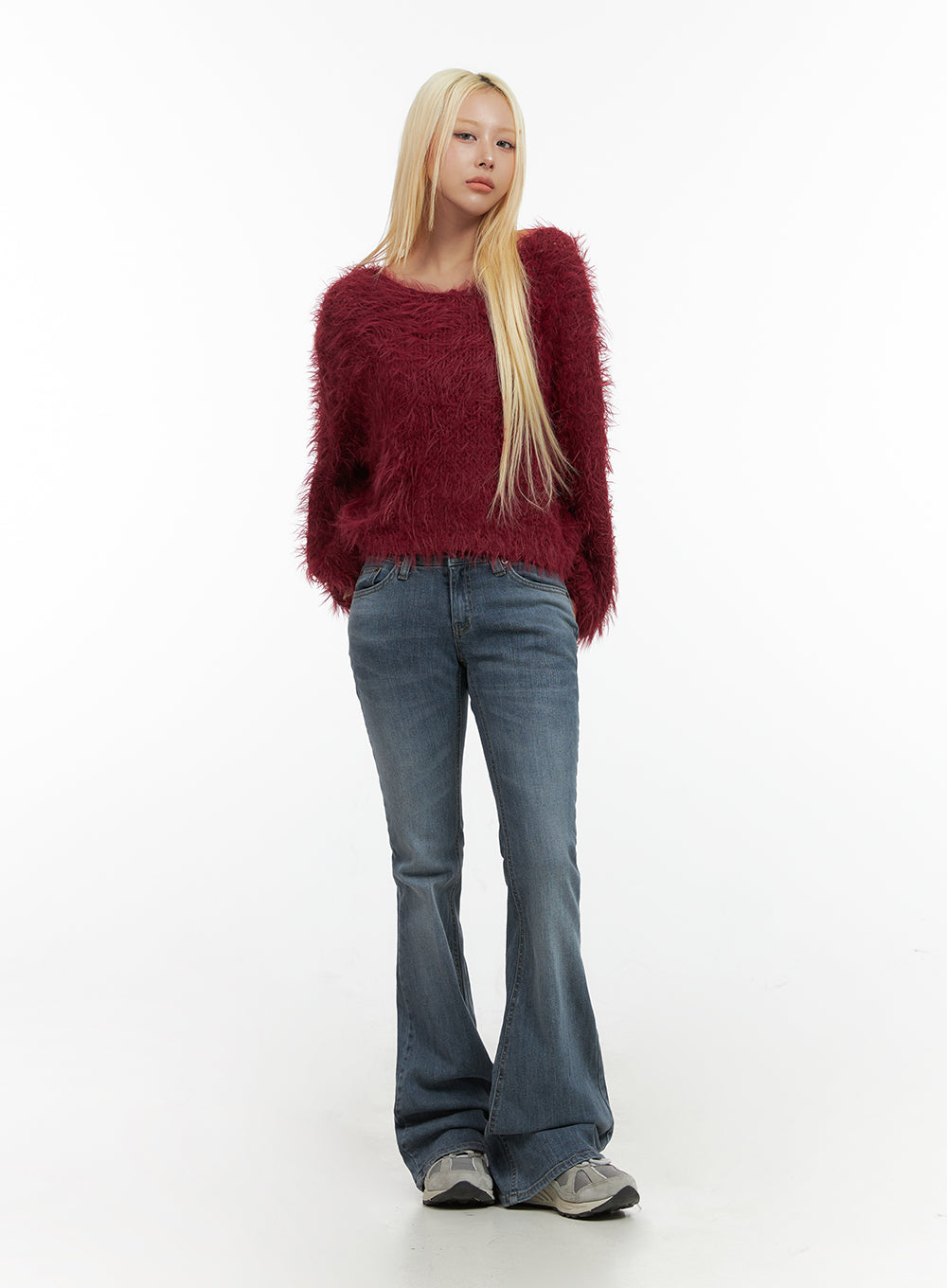 Liv Washed Denim Low Waist Bootcut Jeans CO414 in blue, full-body front shot on model, slim bootcut silhouette, low waist, styled with red shaggy knit top and chunky sneakers.