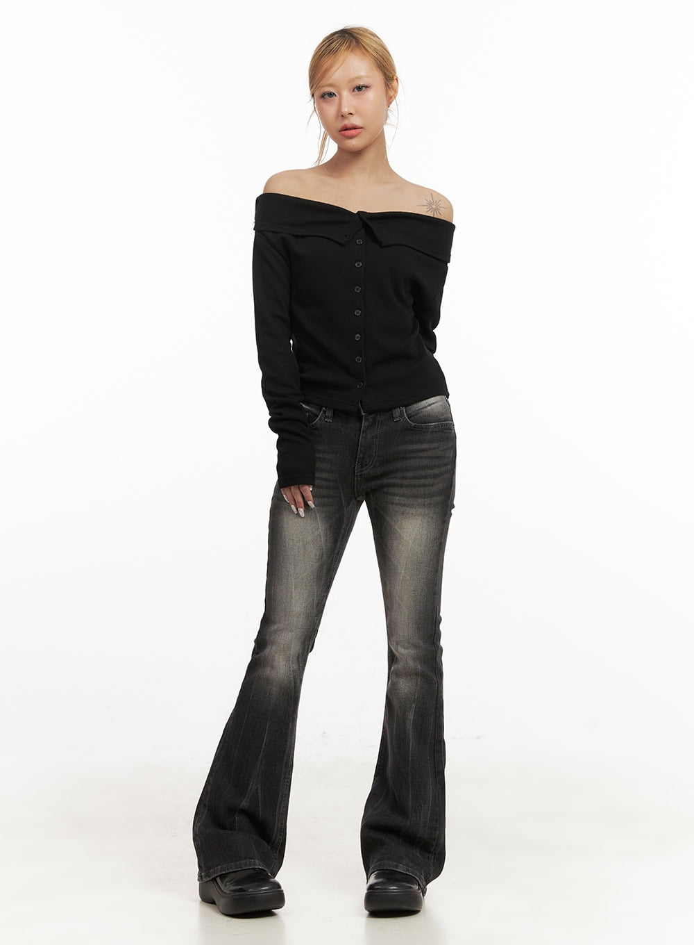 Georgina Low-Rise Flared Jeans CJ507 in black, full-body front view on model, low-rise waistband with five-pocket styling, slim-to-flare silhouette, styled with black off-shoulder knit top and platform loafers.