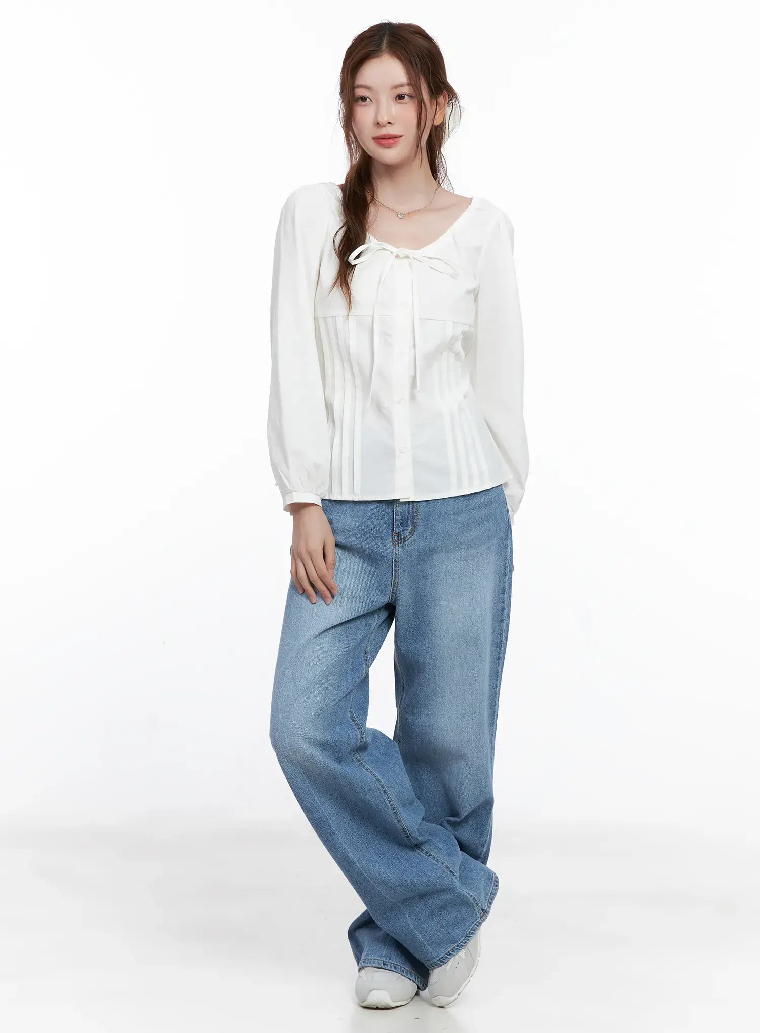 Jung Straight-Leg Washed Jeans CG521 in blue, full-length front shot on model, relaxed wide-leg washed denim styled with a white tie-neck blouse and white sneakers.