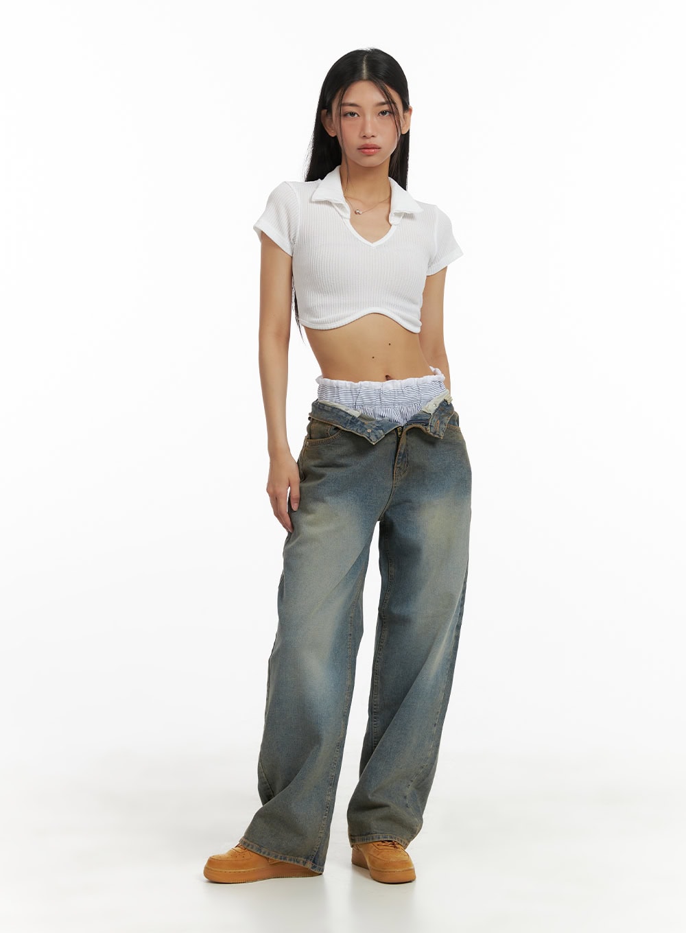 Low Rise Straight Jeans CA424 in dark blue, full-body front on model, low-rise waistband with layered underwear detail, styled with white ribbed crop polo top and tan sneakers.