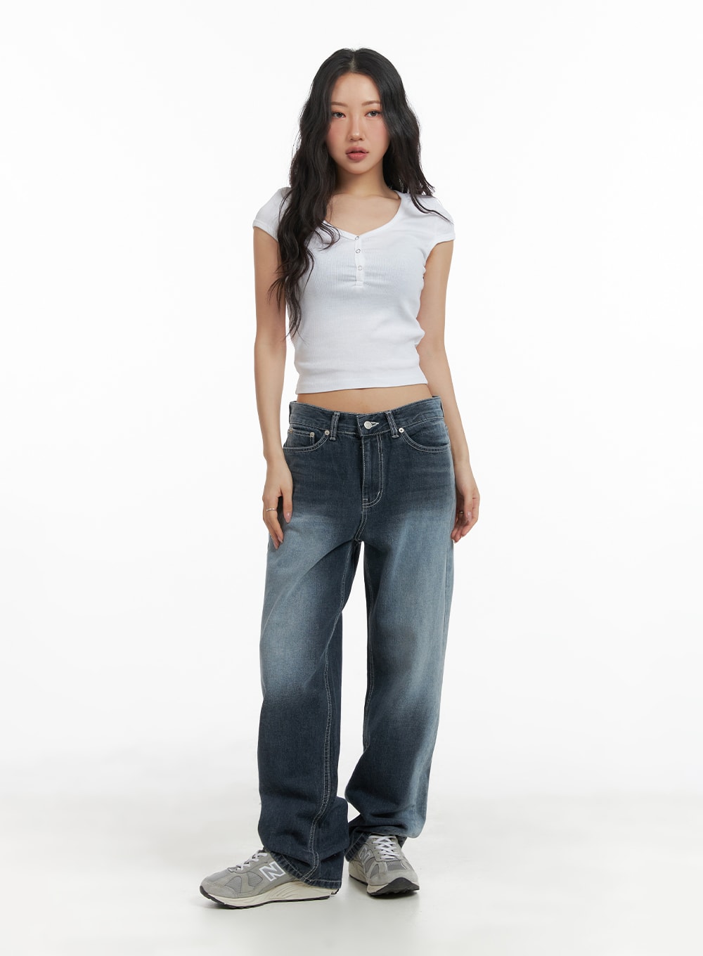 Recycled Wide Baggy Jeans (Unisex) CM425 in dark blue, full-body front shot on female model, baggy wide-leg denim with washed finish, styled with white ribbed henley crop top and New Balance sneakers.