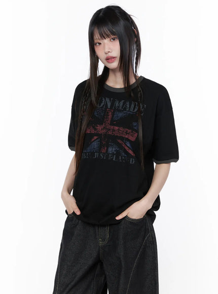 Graphic Short Sleeve Tee CU519 in black, front view on model standing, faded Union Jack graphic with contrast gray ringer collar, paired with dark baggy denim.