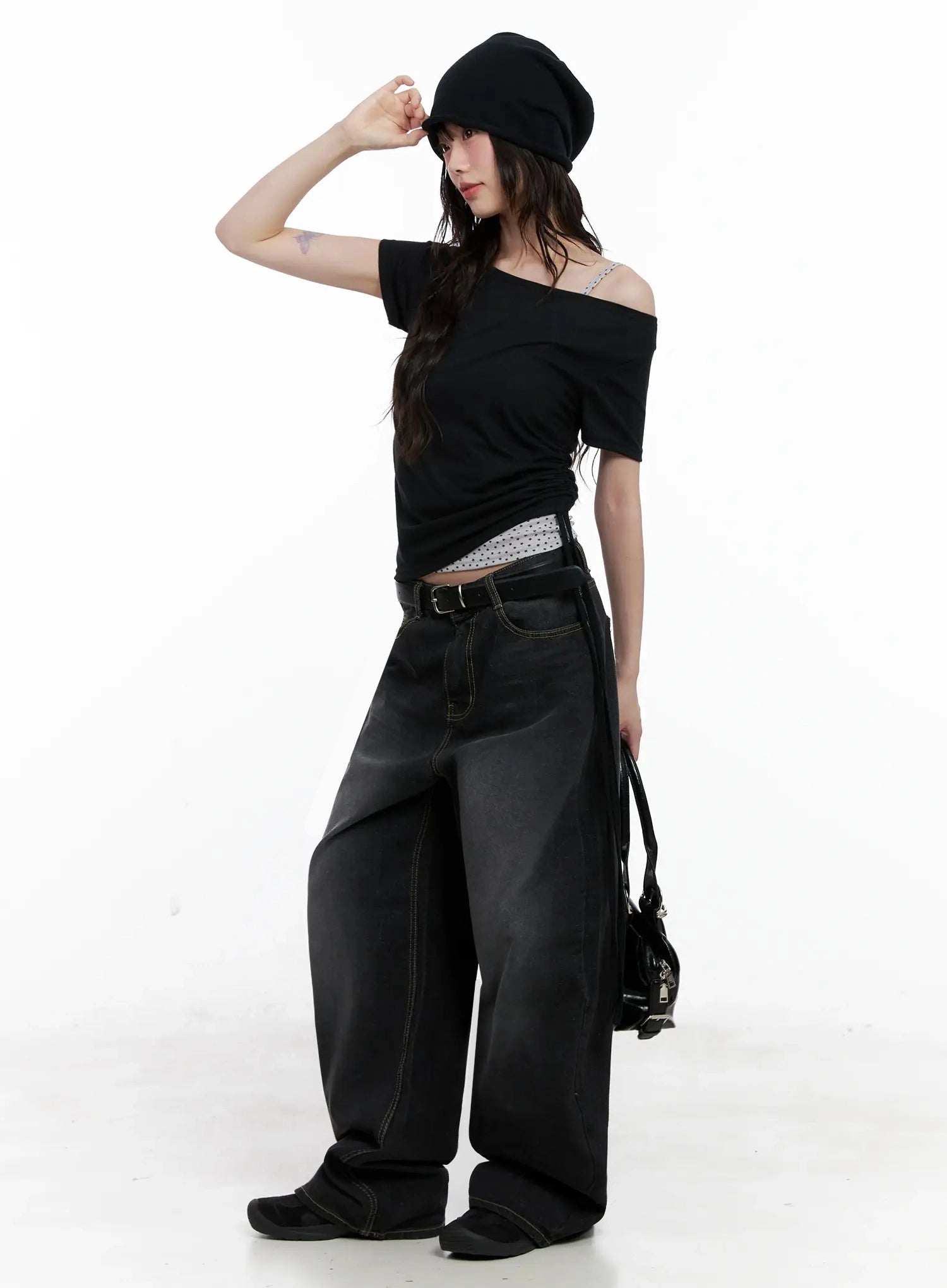IU Vintage Black Baggy Jeans IL528 in black, full-body side-angled editorial shot, model in black off-shoulder top and beret, belted low rise, oversized wide leg silhouette.