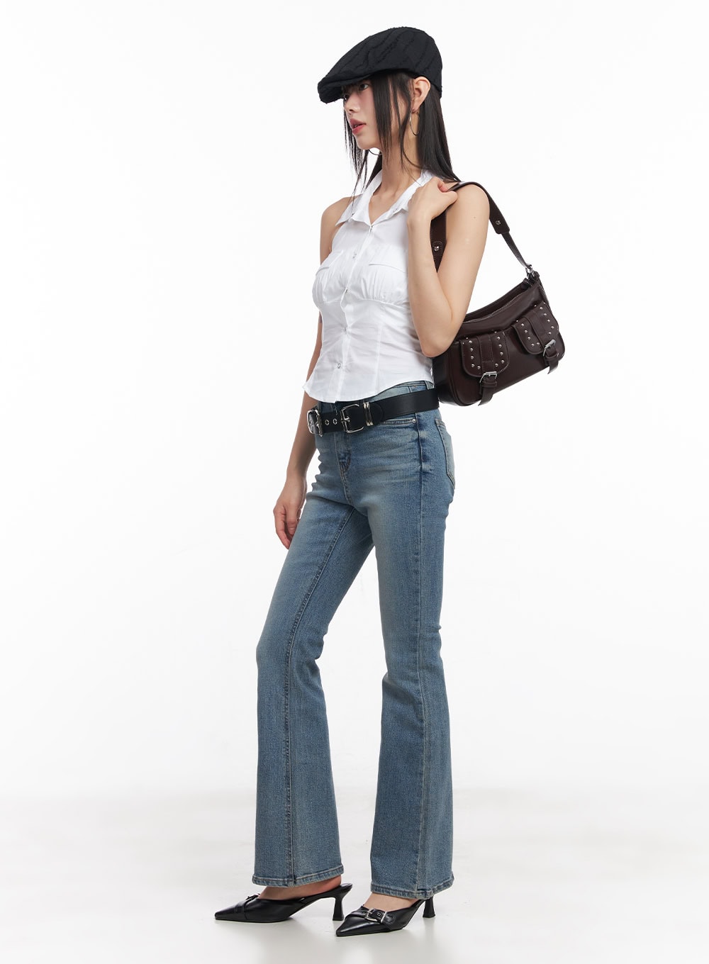 Cassy Slim Washed Flared Jeans CY512 in blue, full-body side view on model, styled with white halter top, black belt, newsboy cap, and brown studded shoulder bag.
