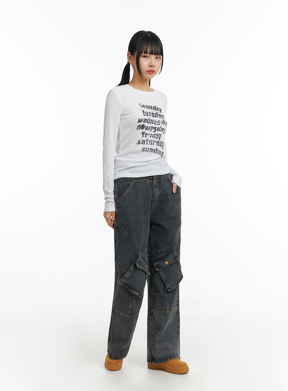 Mid Waist Cargo Jeans CJ411 in dark blue, three-quarter side view on model, wide-leg washed denim with curved seam detailing and snap cargo pockets, styled with white long-sleeve top.