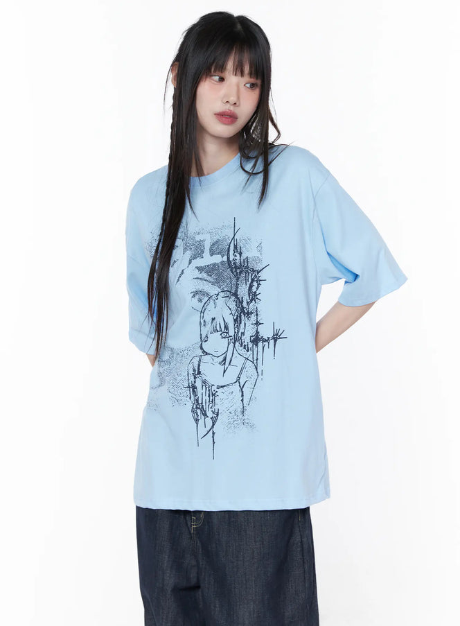 Casual Graphic Short Sleeve Top CU519 in light blue, front half-body shot on model, oversized tee with dark ink anime graphic print, paired with wide-leg dark denim.