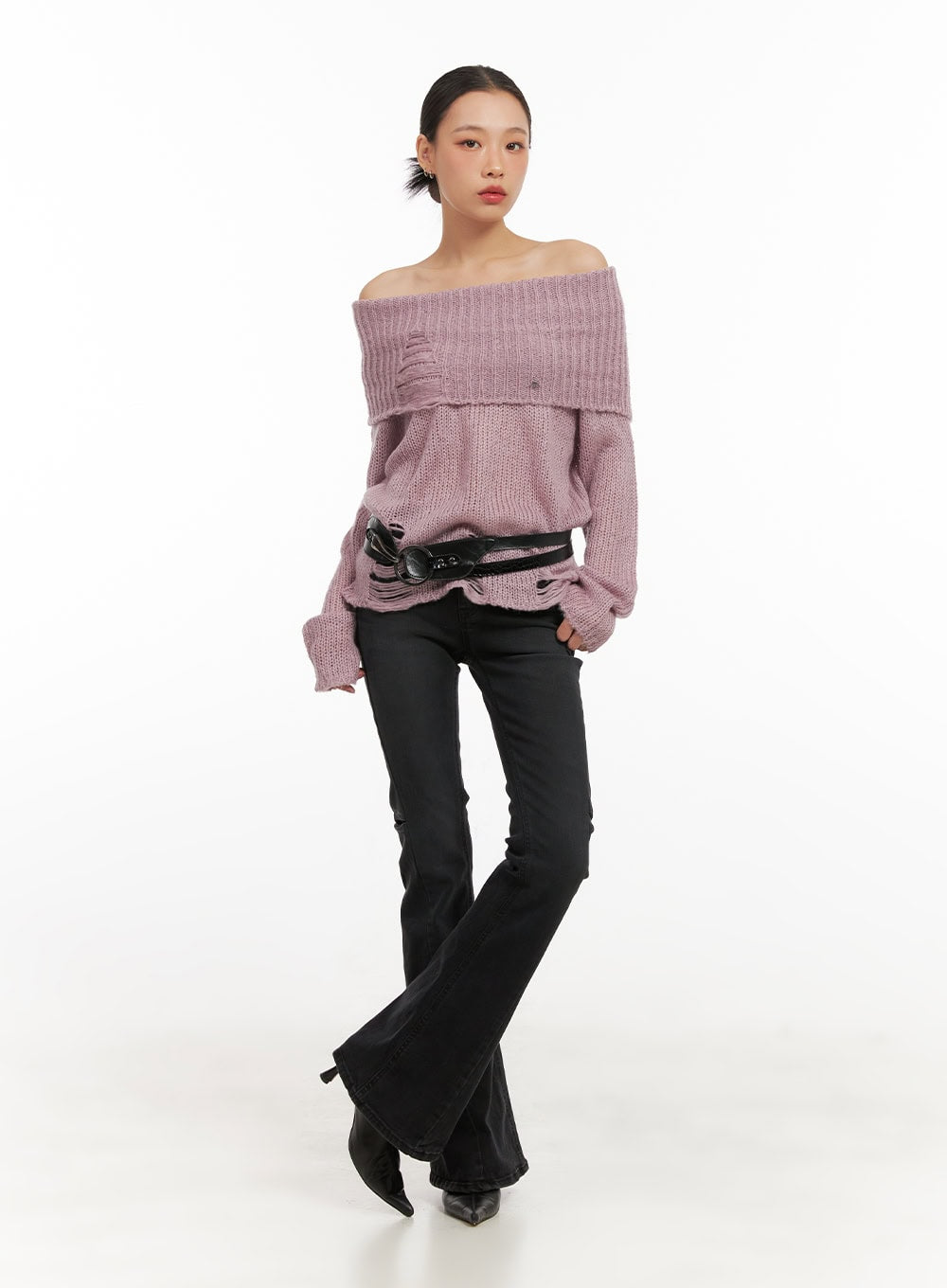 Belle Slim Fit Flared Jeans CD410 in black, full-body front shot on model, low-waist bootcut silhouette paired with pink off-shoulder sweater and black belt.