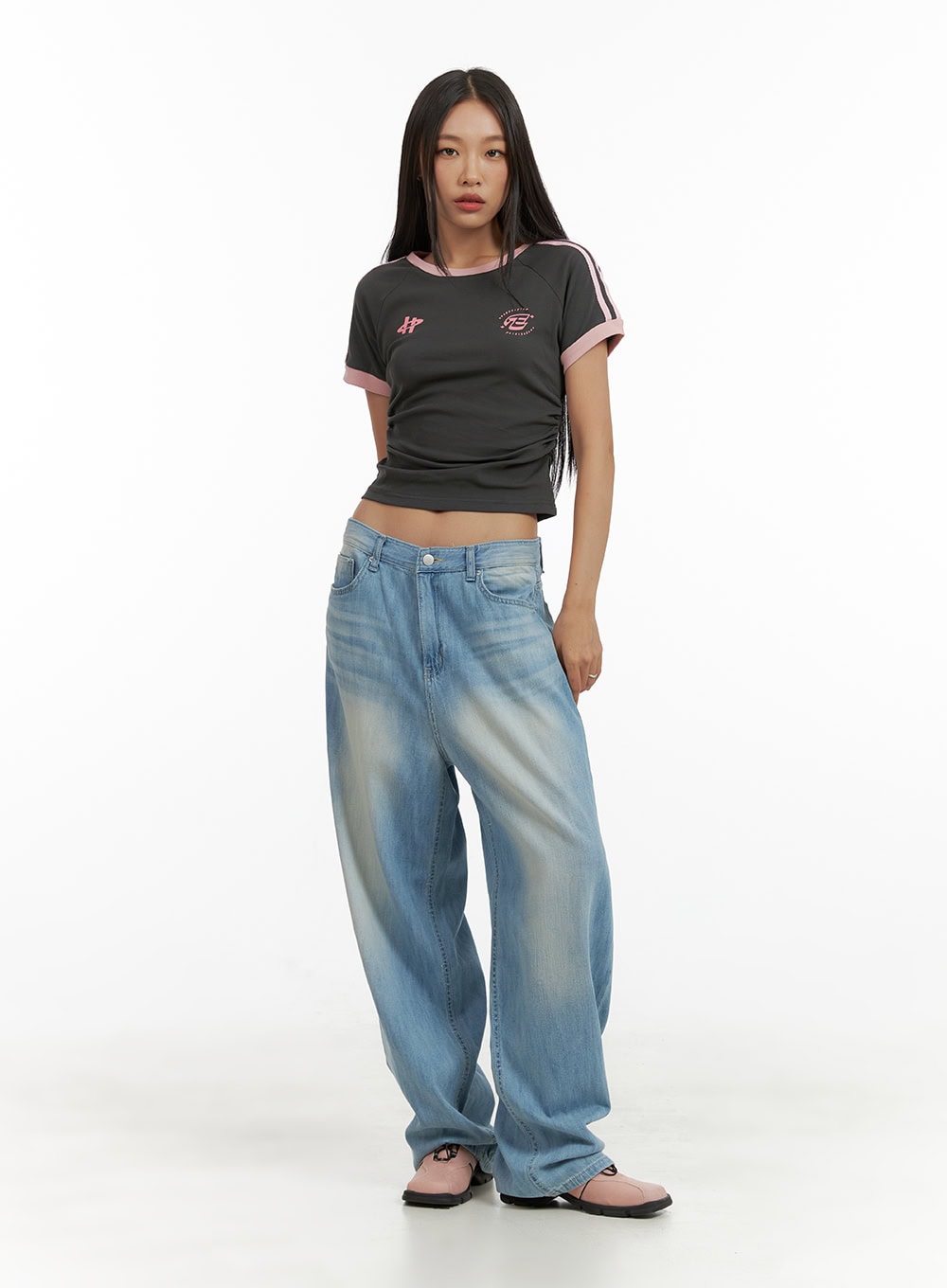 Washed Comfort Baggy Jeans CU414 in light blue, full-body front shot on model, oversized wide-leg silhouette pooling at hem, styled with dark graphic crop tee and pink mules.