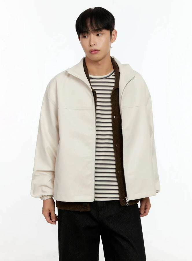 Men's Textured PU Jacket IN506 in light beige, upper-body front on model, open zip, stand collar, drop-shoulder PU shell, layered over stripe tee and brown fleece, black trousers.