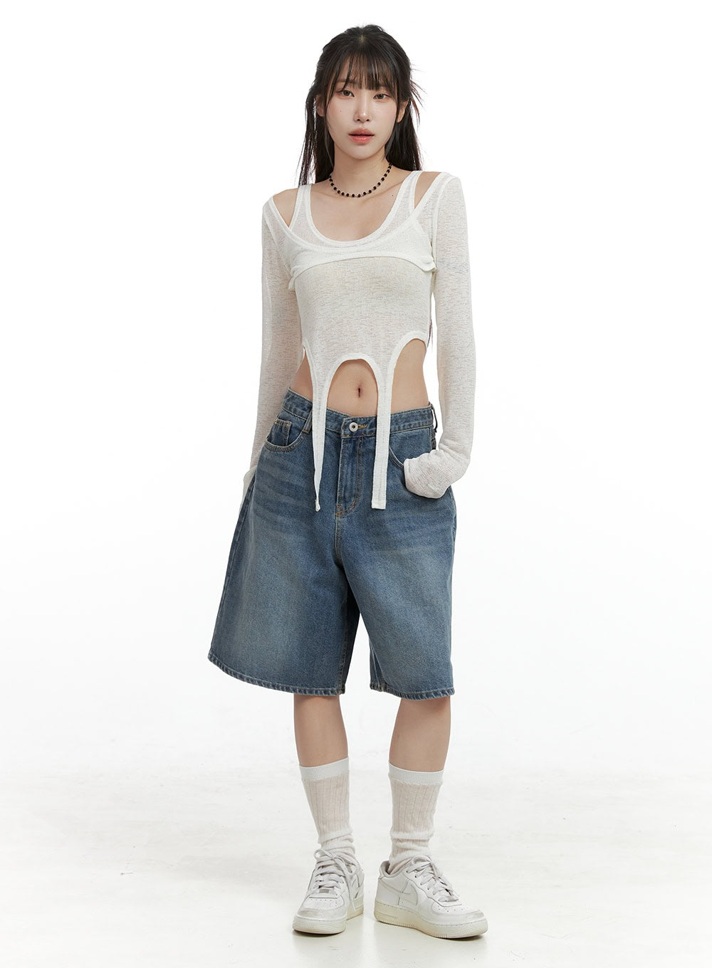 Low Rise Bermuda Jorts CL424 in blue, full-body front shot on model, wide-leg bermuda length washed denim, low rise waist, styled with sheer layered white top and white sneakers.